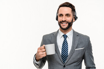 Happy IT support manager chat manager in headset drinking coffee isolated over white background. Caucasian hotline worker online on line, telemarketing telework concept