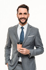 Vertical shot of successful young businessman drinking coffee from paper disposable cup isolated over white background. Rich manager banker drinking hot beverage tea