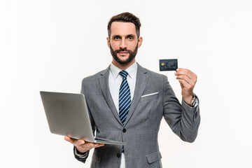 Serious young businessman using laptop for e-banking isolated over white background, Credit debit card, e-commerce, loan, mortgage, debt and accountancy, savings and salary