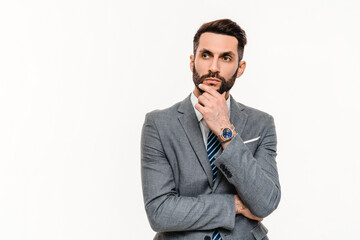 Fototapeta premium Pensive young businessman in grey suit thinking about promotion isolated over white background. Contemplative thoughtful smart manager banker dreaming
