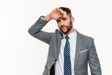 Tired young businessman wearing suit isolated over white background. Exhausted depressed overworked...