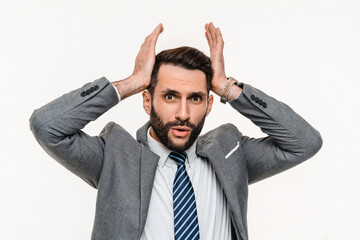 Shocked young businessman hearing news isolated over white background. Amazement panic, fear, being...