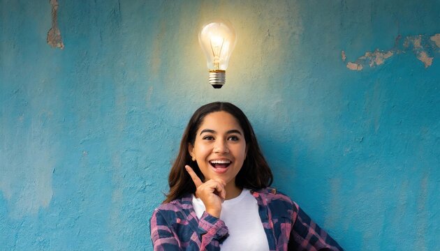 Illuminated light bulb above the head of a young woman, the concept of having an idea of a surprised girl with eureka on an old blue wall 
