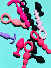 Set of sex toys. anal plugs and dildo over blue backdrop - obrazy, fototapety, plakaty
