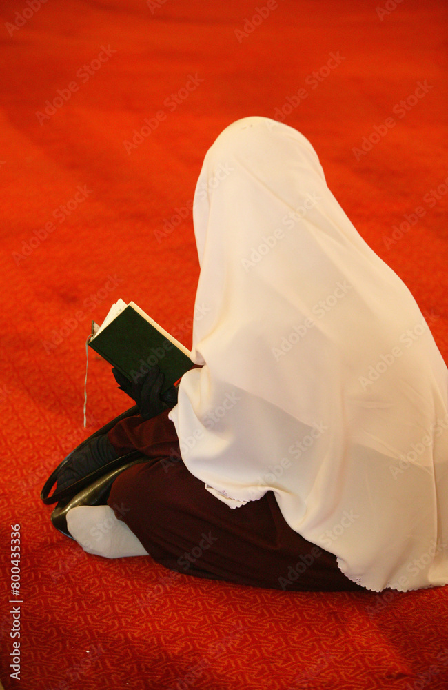 Sticker muslim woman reading the quran in a mosque.