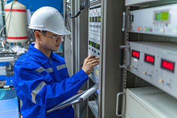 Electrical engineer woman checking voltage at the Power Distribution Cabinet in the control...