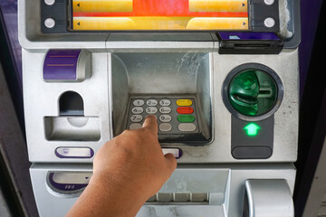 Close up of hand entering code at atm machine