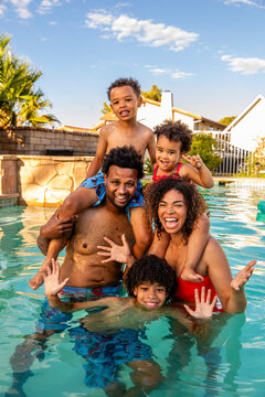 Happy Family Poses Excitedly For The Camera While At The Pool 