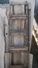 Old wooden ladder on the background of broken slate and building material