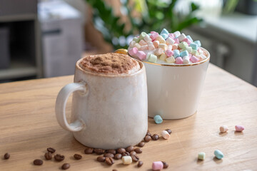 A cozy scene with a cocoa dusted cappuccino and a mug overflowing with marshmallows, a sweet treat on a wooden table.