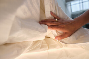 A pair of hands touching and feeling a comfy bed spread cotton duvet. Great night sleep and comfort...