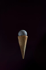 A microphone is placed inside of an ice cream cone. The cone is upside down and the microphone is...