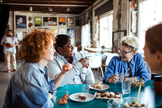 Multigenerational and diverse group of people having lunch together in a startup company office