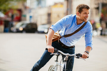 Active businessman riding bicycle in city street