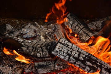 Flames consume firewood in this close up of campfire creating a warm comfy atmosphere in the night...