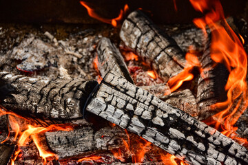 Flames consume firewood in this close up of campfire creating a warm comfy atmosphere in the night...