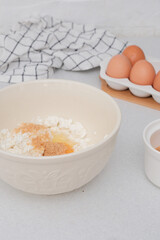 Home kitchen interior.Bowl with dough, eggs and bowl of sugar on kitchen table in modern kitchen.