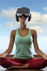 Fototapeta premium A young woman wearing a virtual reality headset is meditating in a yoga pose.