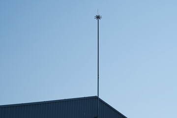 Lightning rod against blue sky. Active lightning protection of a building. Place for text. - obrazy, fototapety, plakaty