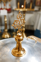 Fototapeta na wymiar golden church cross on the lid of the baptismal font for a baby