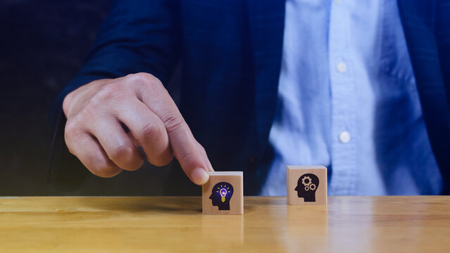 Thinking skills for business leader and manager concept. creative, systematic thinking skill, Hand business picked wooden cube block with head human symbol and light bulb icon creative idea concept.