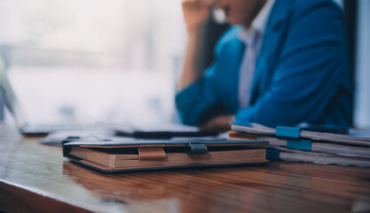 Asian Business woman using calculator and laptop for doing math finance on an office desk, tax,...