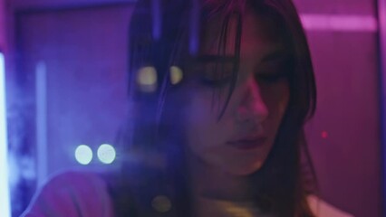 Neon girl holding lighter in night club portrait. Serious woman posing closeup