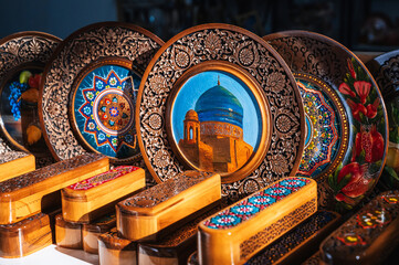 Uzbek wooden gift plates and caskets with wood carvings hand-painted asian patterns in the souvenir...