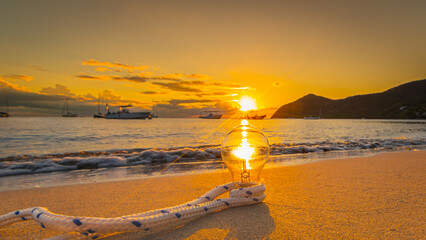 Ampoule en verre au coucher de soleil à La Grande Anse d'Arlet à La Martinique, mer des...