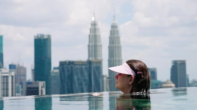 Woman In Rooftop Infinity Pool With Petronas Twin Towers In The Background In Kuala Lumpur, Malaysia. Closeup Shot