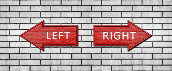 Red wooden arrow signs with the inscription LEFT and RIGHT hang on a white brick wall. Right and...