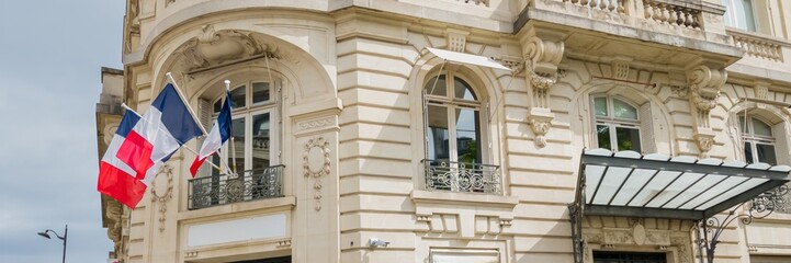 Elegant French architecture with national and regional flags fluttering, symbolizing French...