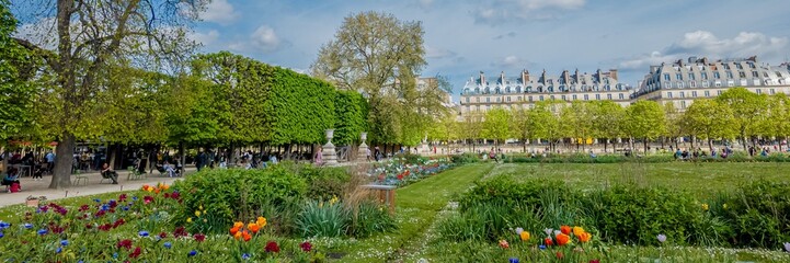 Scenic view of a bustling public park in spring with lush greenery and colorful tulips against...