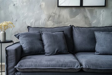 A close-up view captures the refined elegance of a grey sofa against a textured stucco wall, showcasing the sophistication of an art deco-inspired modern living room interior design