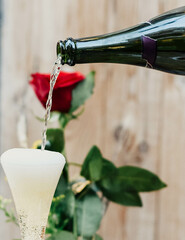 Una rosa roja acompañada de una copa de champagne