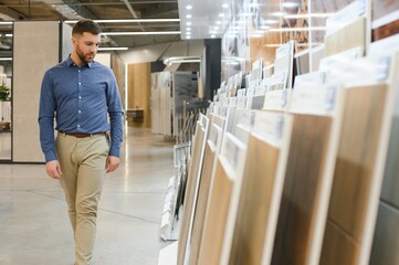 Middle age man choosing ceramic tiles and utensils for his home bathroom