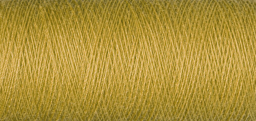 macro texture of a skein of yellow sewing thread