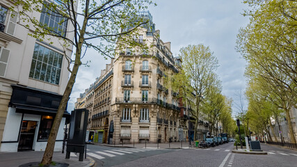 Paris, France, April 14th, Tranquil Parisian street with classic Haussmannian architecture in...