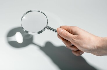 Woman using magnifying glass, searching, analyzing documents. Business research, detective work in