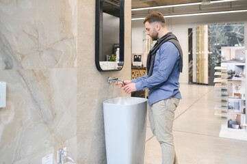 Man choosing bathroom sink and utensils for his home