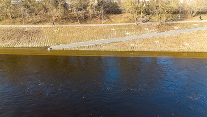 Drone photography of flooded riverside bank in a city during spring day