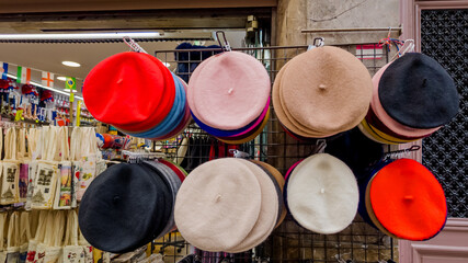 Assorted colorful berets on display in a retail store, representing French fashion and culture,...