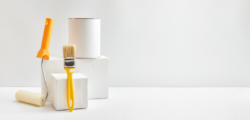 Geometric podium or pedestal with paint can, brush, sponge roller on a white background. Mock up...