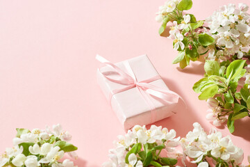 Spring flowers and  gift box on a pink background