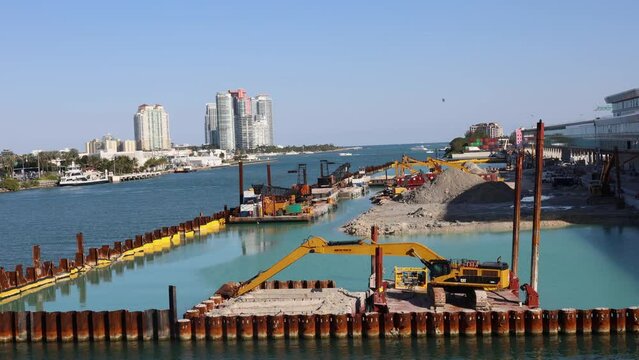 High angle crane shot of construction site in sea against clear blue sky at Miami port in Florida
