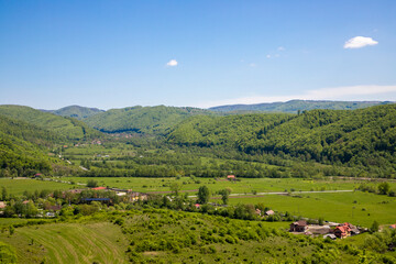 Obraz premium Landscape with a countryside area from Tranilvania - Romania. Aerial view of a rural area with hills, valleys and houses from the Eastern Europe