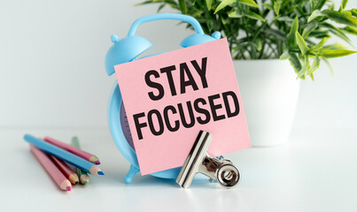 Stay Focused write on Sticky Notes on on a clock in the form of an alarm clock.