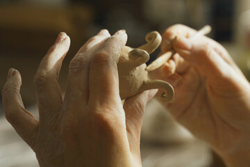 A woman makes a clay product with her hands - a ceramic pot.