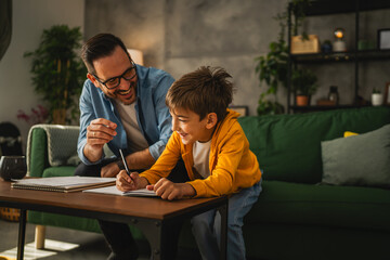 Father and son do homework together at home