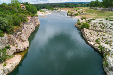 Panoramic view of River Gardon seen from ancient old Roman Aqueduct Pont du Gard ear Vers-Pon-du-Gard, Occitanie, France, Europe. Unesco world heritage site near Nimes, Languedoc-Roussillon - obrazy, fototapety, plakaty